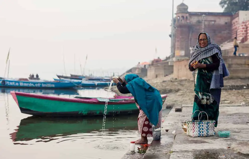 Praying on the banks of the Ganges River, a Hinduism holy place, in the city of Varanasi in India.