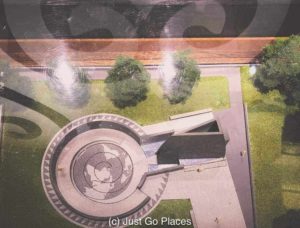 A diorama of the outdoor part of the African Burial Ground National Monument under the shadow of the sankofa symbol.