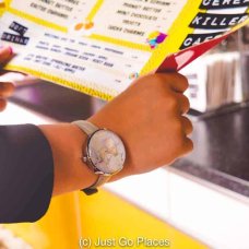 Examining the menu at Serial Killer Cafe Camden