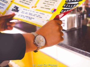 Examining the menu at Serial Killer Cafe Camden