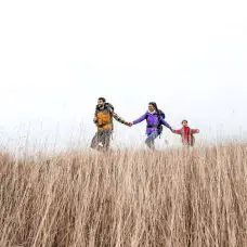 family backpacking through grass