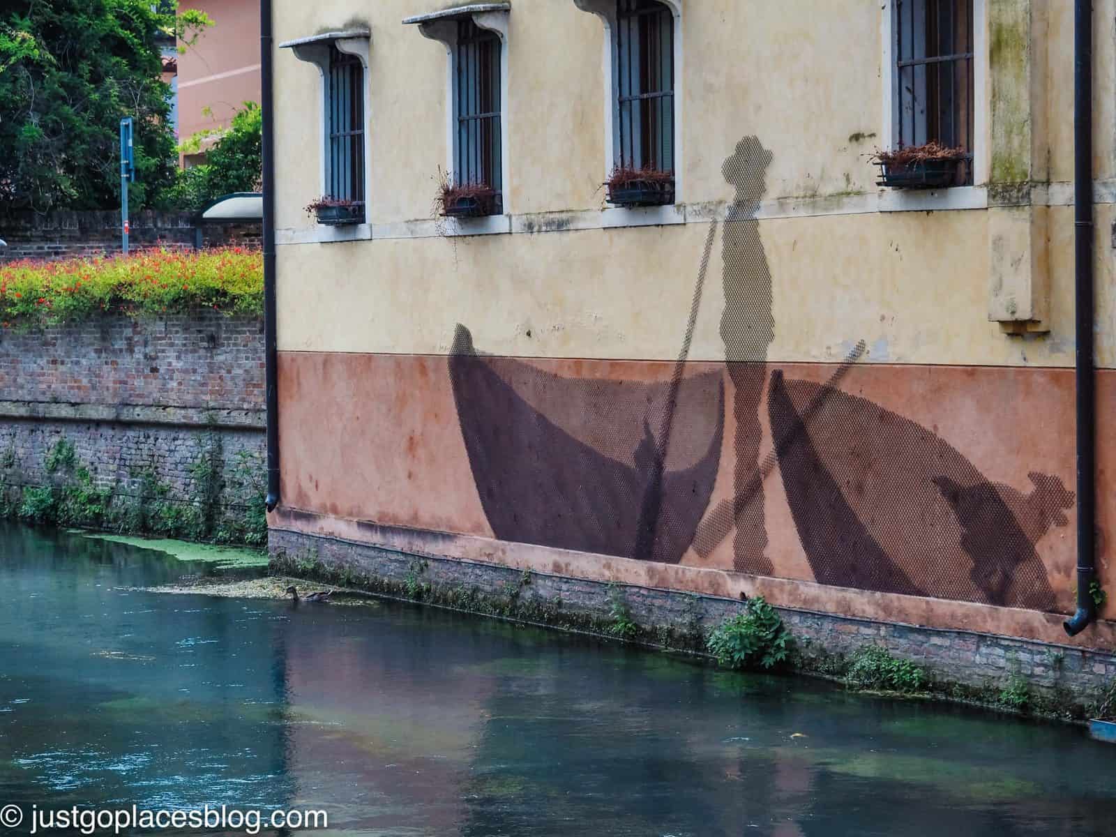 Street art of fisherman and nets canalised in Treviso