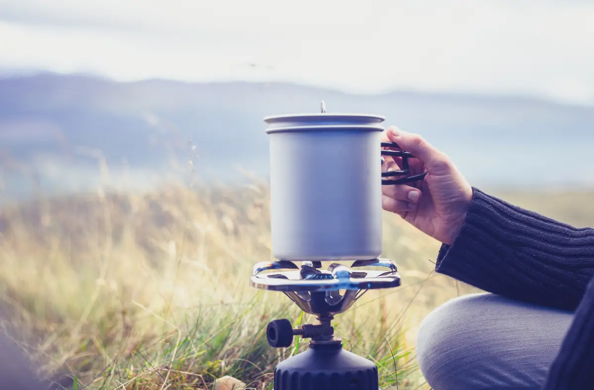 heating a mug on a camping stove outdoors